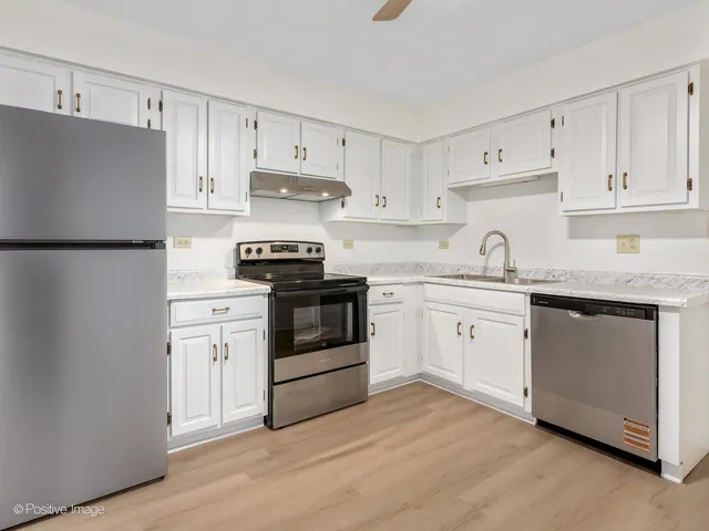 a kitchen with white cabinets and white appliances