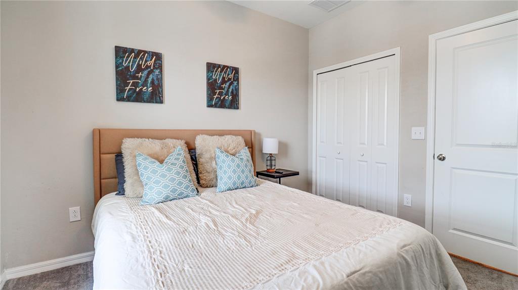 31632 Blue Passing Loop Wesley Chapel, FL 33545 - Photo 41 of 48 a bedroom with a large bed and a walk in closet