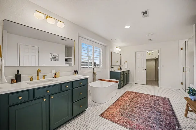 a spacious bathroom with a double vanity sink a toilet and a mirror