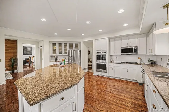 a large kitchen with kitchen island a large counter top stainless steel appliances and cabinets
