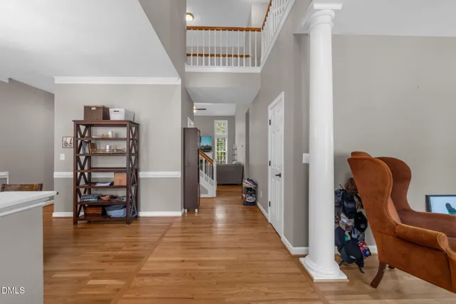 a view of a hallway with wooden floor and furniture