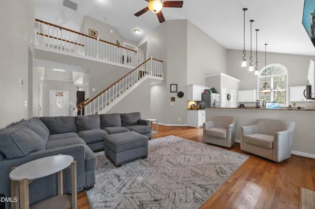 a living room with furniture kitchen view and a chandelier