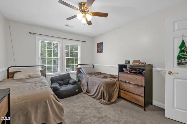 a spacious bedroom with two beds and a chandelier