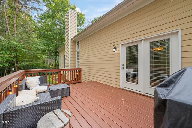 a balcony with wooden floor and outdoor seating