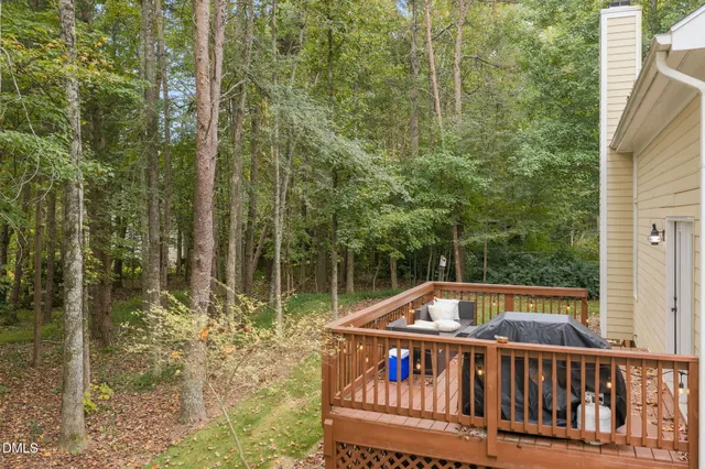 a view of a white house next to a yard and large trees