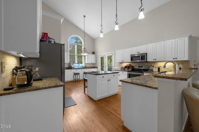 a kitchen with granite countertop a sink cabinets and wooden floor