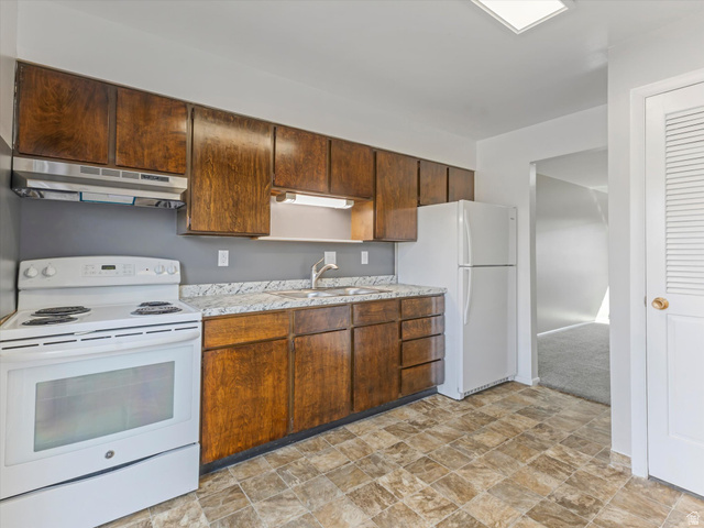 1478 North 75 West, Unit AD Sunset, UT 84015 - Photo 18 of 26 Kitchen featuring white appliances, stone finish floors, and light countertops