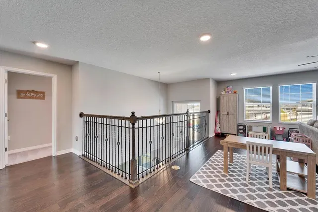 a bedroom with a bed a dresser and painting on the wall