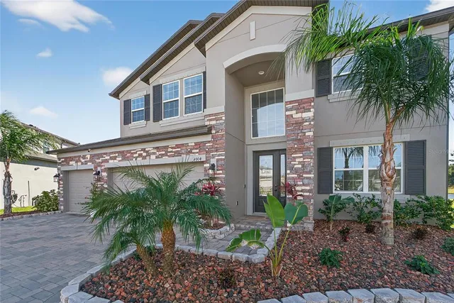 a large white kitchen with granite countertop a stove top oven a sink dishwasher and white cabinets with wooden floor