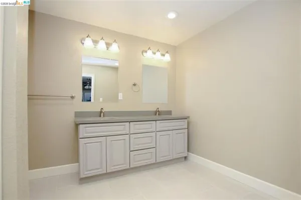 a bathroom with a double vanity sink and a mirror