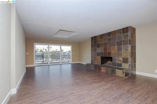 a view of empty room with wooden floor and fireplace