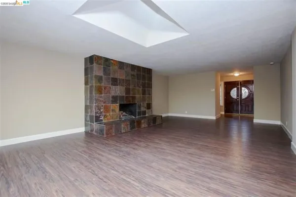 an empty room with wooden floor and furniture