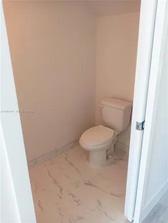 a white toilet sitting next to a shower