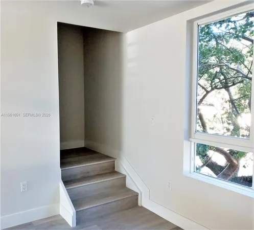 a view of entryway with wooden floor and front door