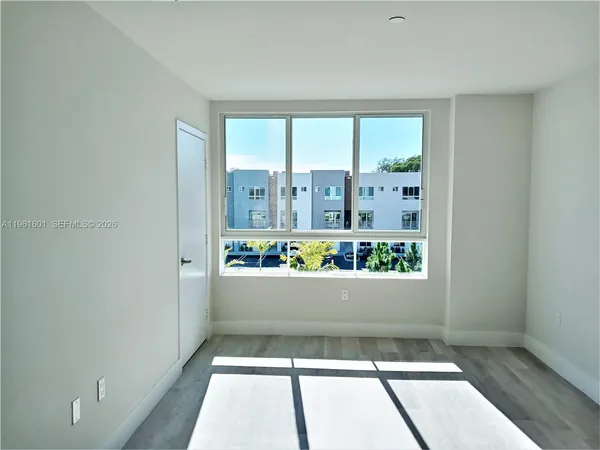 a view of room with window and refrigerator