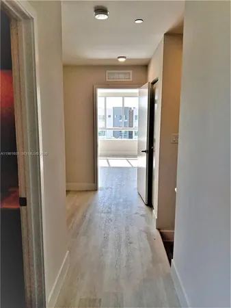a view of hallway with wooden floor