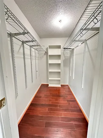 a view of a hallway with wooden floor and entryway