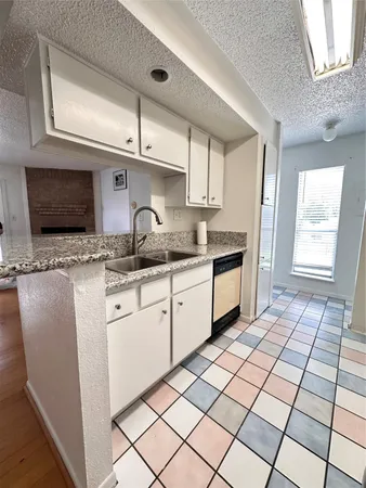 a kitchen with a sink window and cabinets