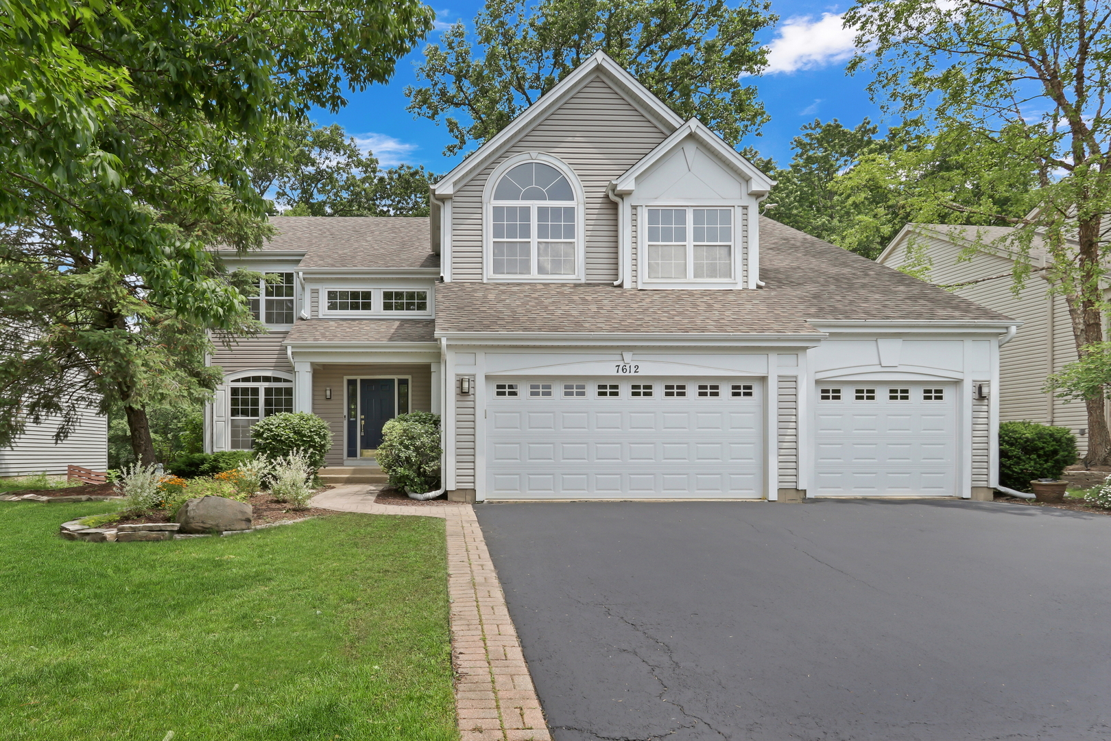 7612 Cascade Way Gurnee, IL 60031 - Photo 1 of 1 a front view of a house with a garden and yard
