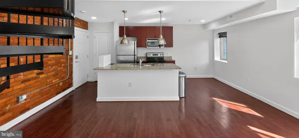 a kitchen with stainless steel appliances granite countertop a stove and a wooden floors