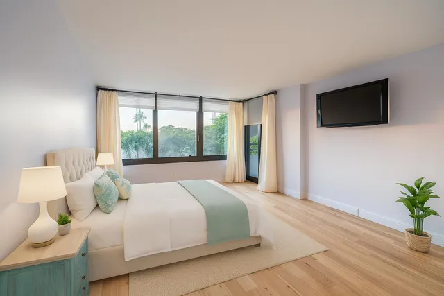 a bedroom with a large bed and a flat screen tv