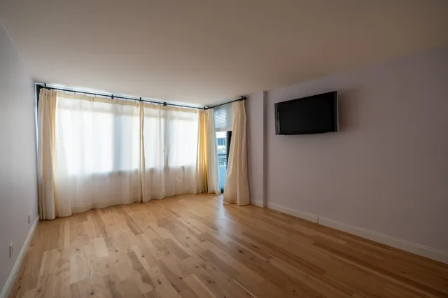 a view of a livingroom with wooden floor and a flat screen tv