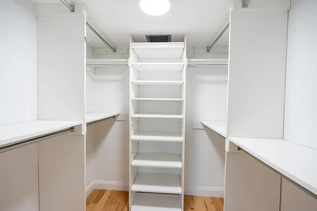 a view of walk in closet with empty racks