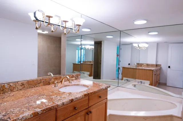 a bathroom with a sink a large mirror and vanity