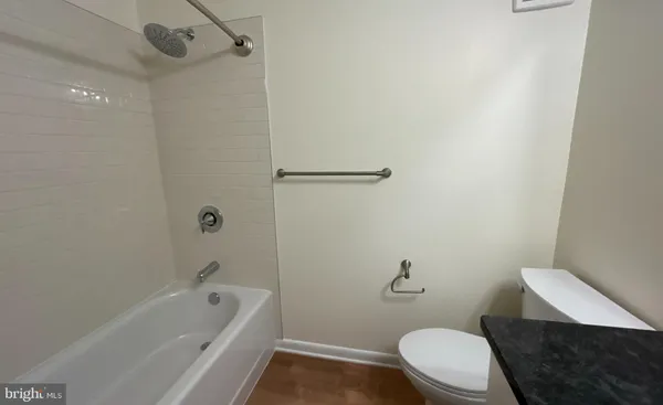 a white toilet sitting next to a bath tub