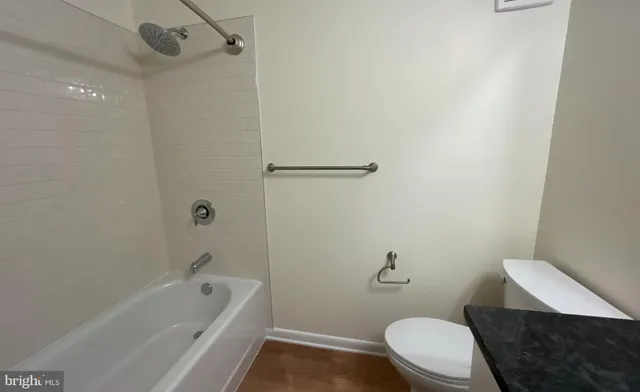 a white toilet sitting next to a bath tub