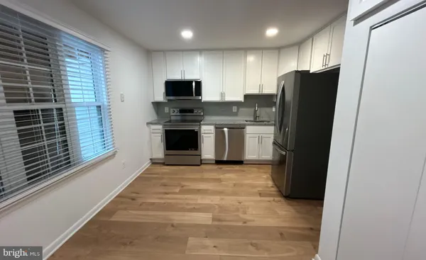 a kitchen with stainless steel appliances granite countertop a refrigerator a stove a sink and a microwave