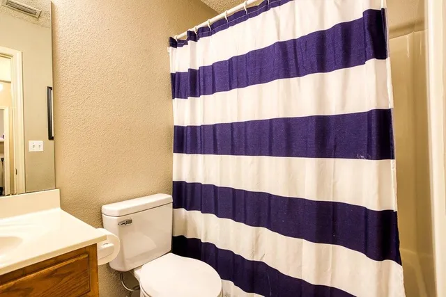a bedroom with a large bed chandelier and a window