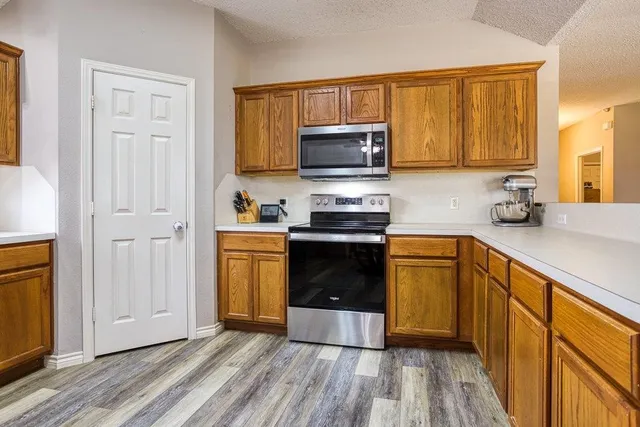 a kitchen with a sink a stove top oven and wooden floor
