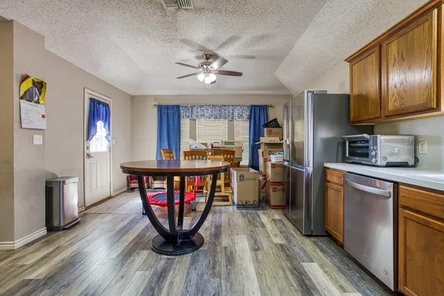 a kitchen with stainless steel appliances granite countertop a refrigerator a stove a sink dishwasher and wooden floor