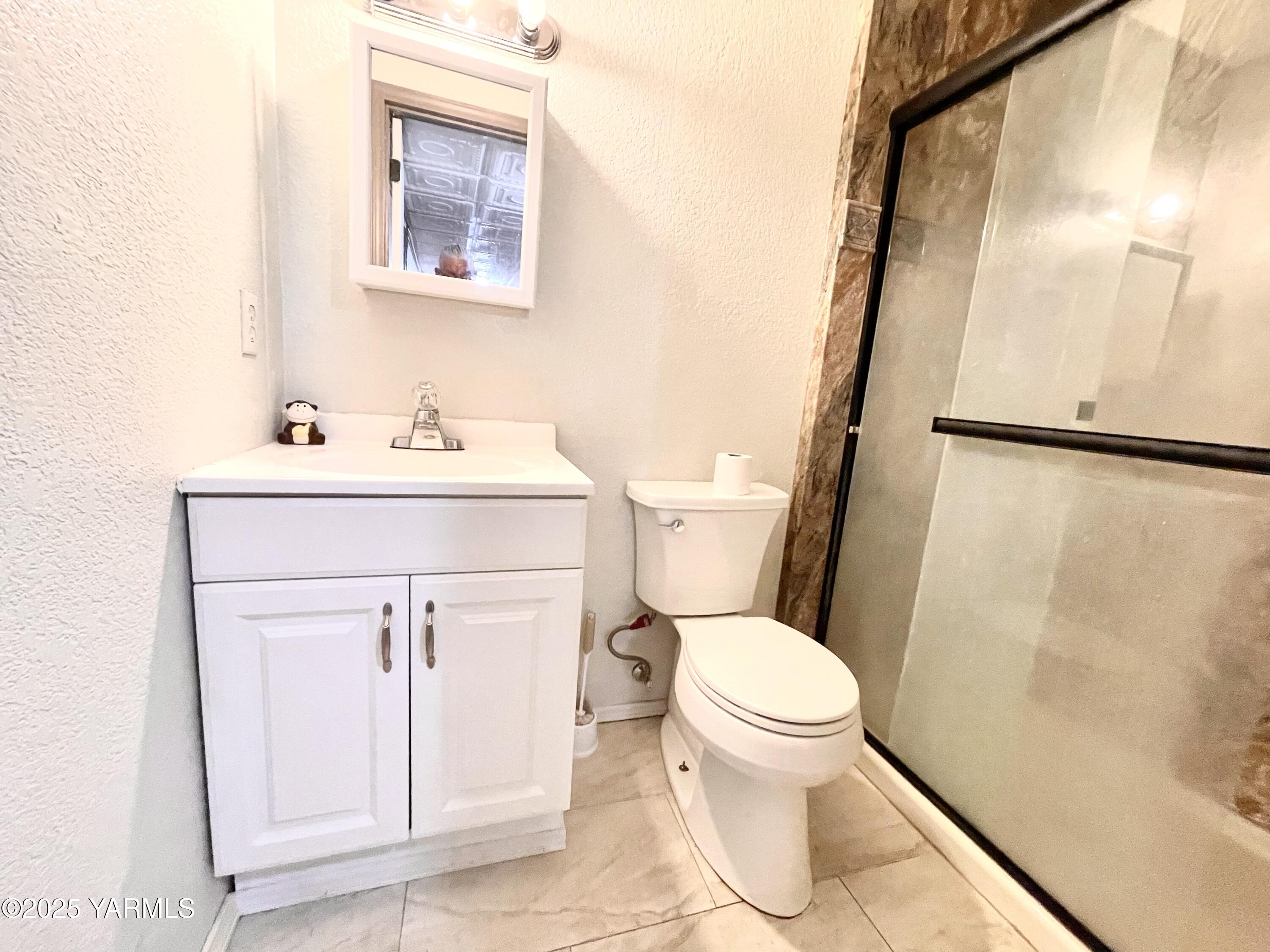 13010 Wide Hollow Road Yakima, WA 98908 - Photo 12 of 19 a bathroom with a sink a toilet and a mirror