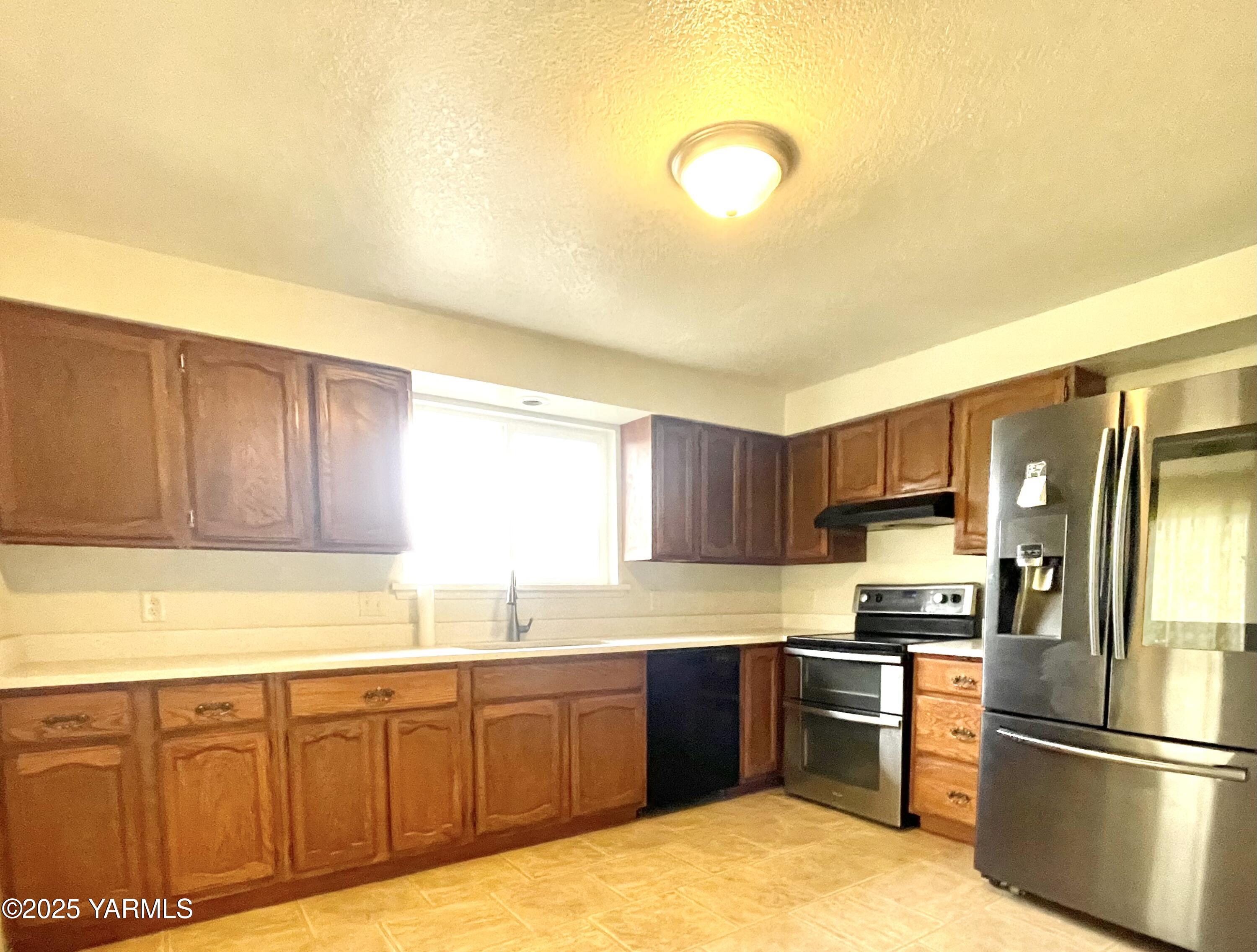 13010 Wide Hollow Road Yakima, WA 98908 - Photo 2 of 19 a kitchen with granite countertop a refrigerator stove top oven and sink
