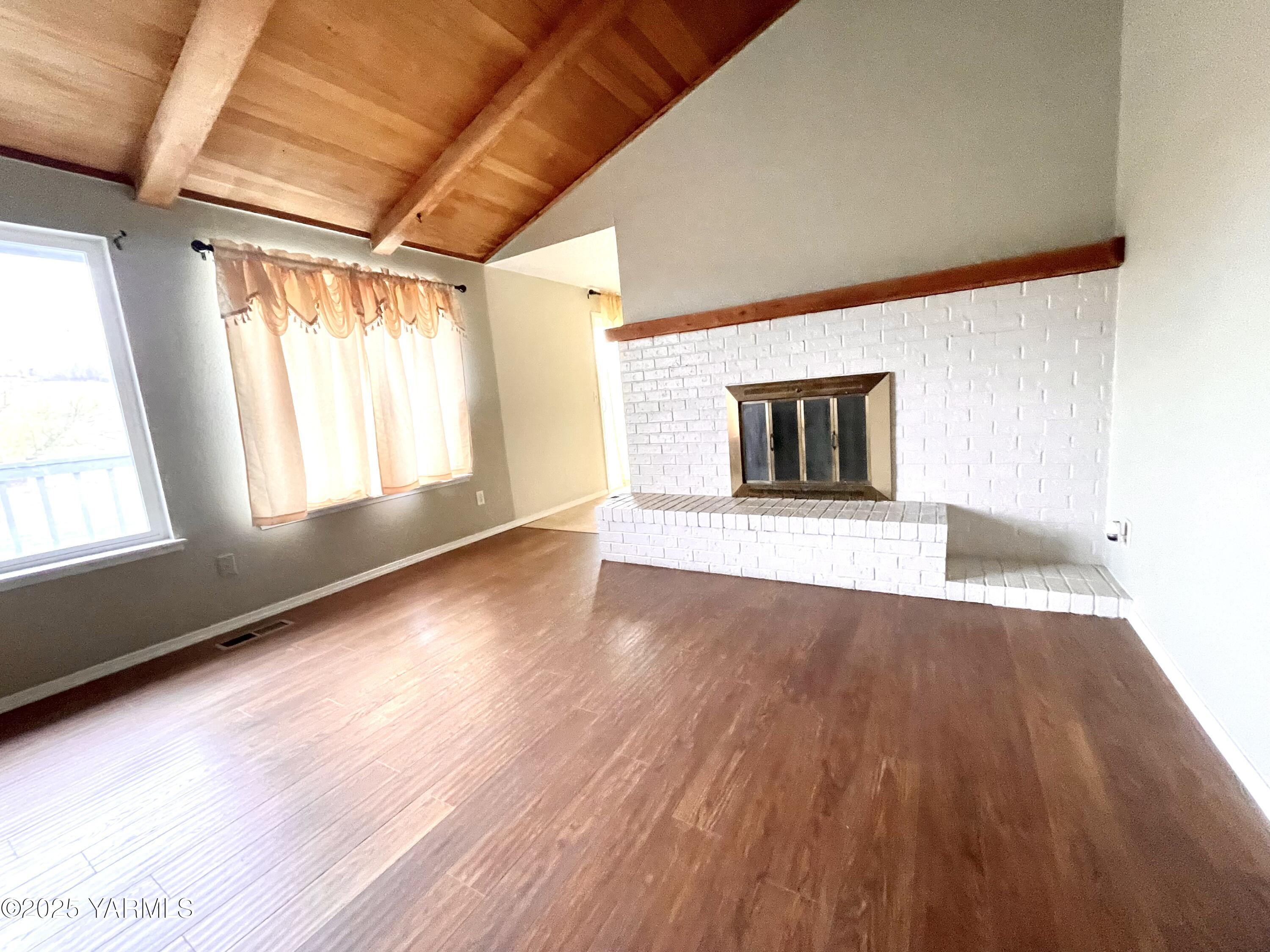 13010 Wide Hollow Road Yakima, WA 98908 - Photo 3 of 19 a view of an empty room with wooden floor and a window