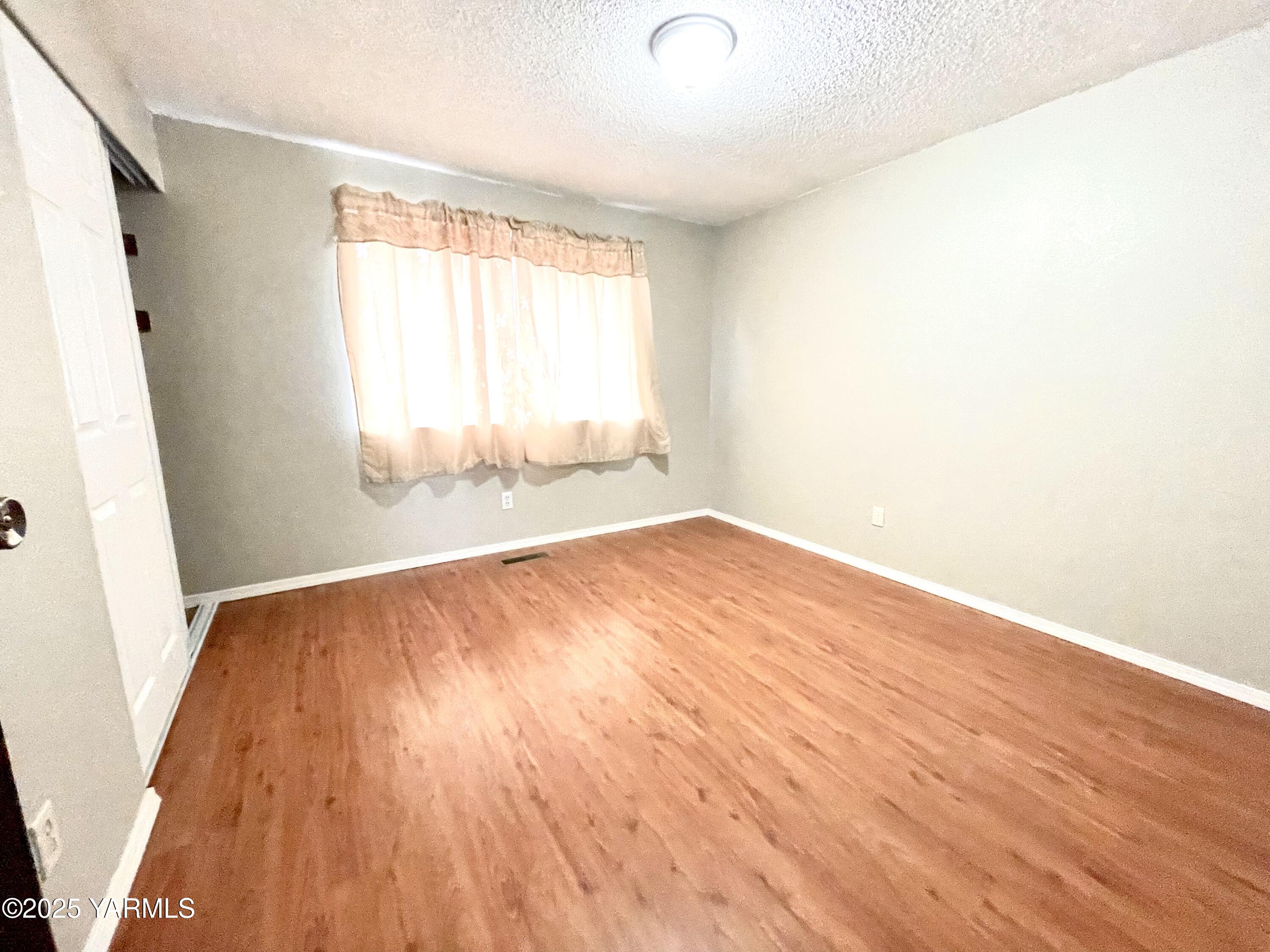 13010 Wide Hollow Road Yakima, WA 98908 - Photo 5 of 19 an empty room with wooden floor and windows