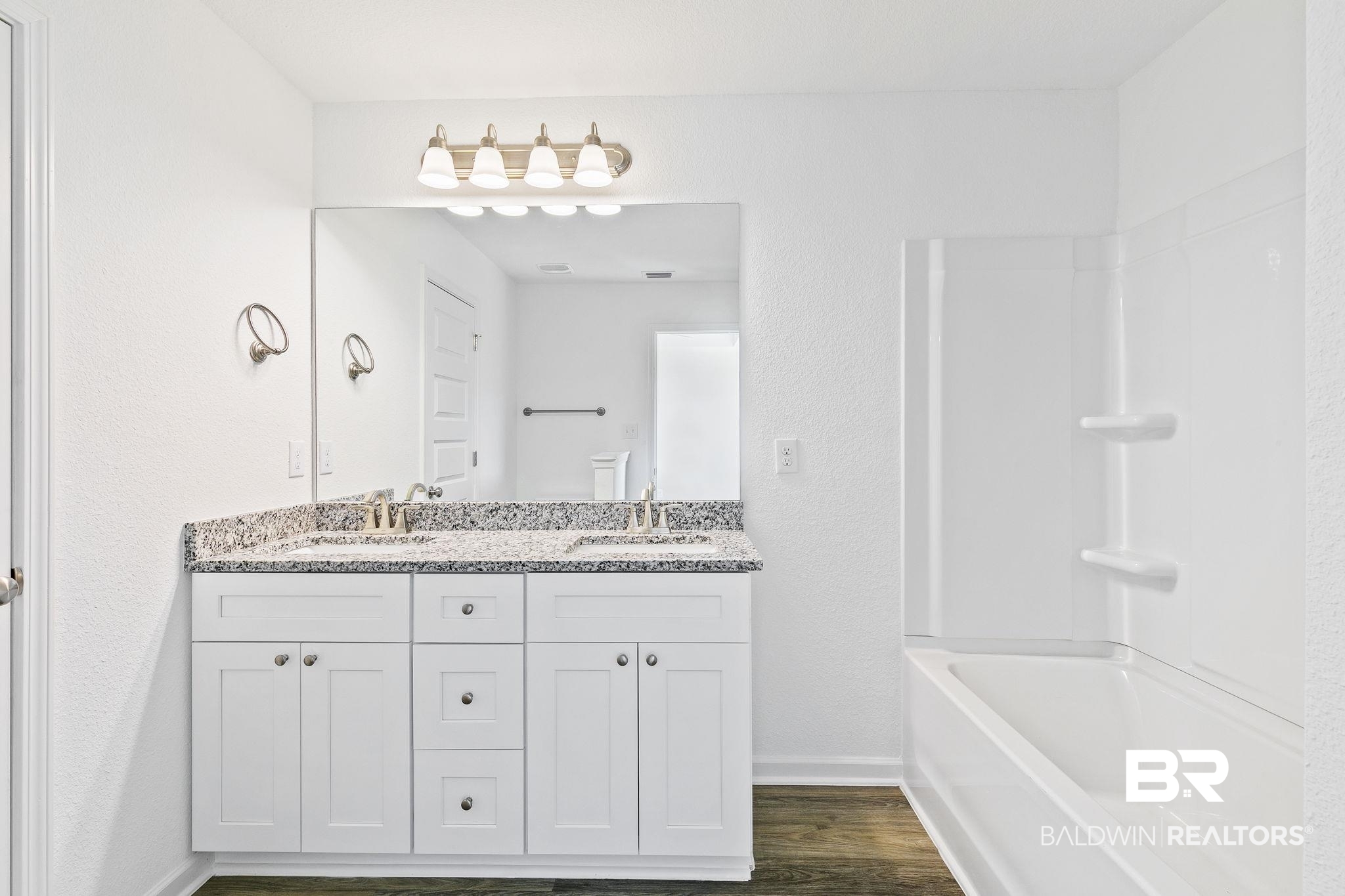 16014 Alabama Avenue Silverhill, AL 36576 - Photo 22 of 50 Bathroom featuring vanity, wood-type flooring, and shower combination