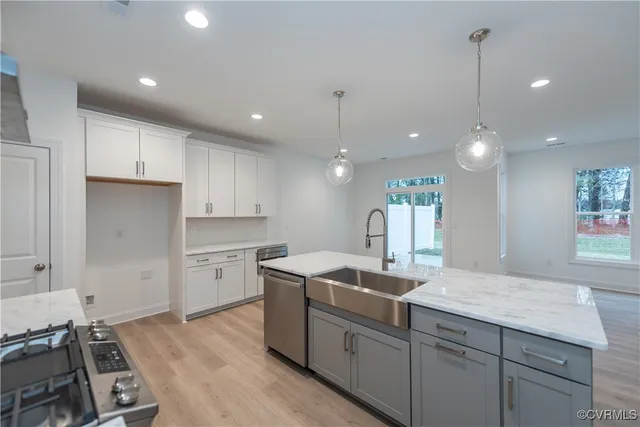 a kitchen with kitchen island a sink stainless steel appliances and cabinets