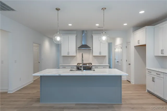 a large kitchen with stainless steel appliances a large counter top a refrigerator and a sink