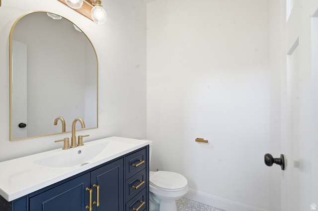 338 Windy Rdg Drive Smithfield, UT 84335 - Photo 19 of 63 Bathroom vanity featuring a navy base, gold-tone hardware, and a white countertop with an integrated sink
