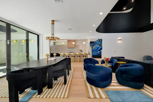 a kitchen with a dining table chairs sink and white cabinets