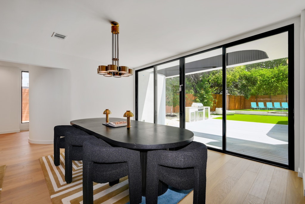 7809 Woodrow Avenue Austin, TX 78757 - Photo 14 of 40 a dining room with furniture a chandelier and wooden floor