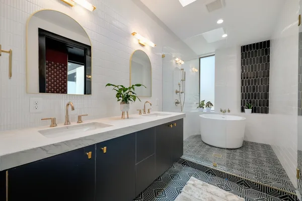 a bathroom with a sink a potted plant and a bathtub