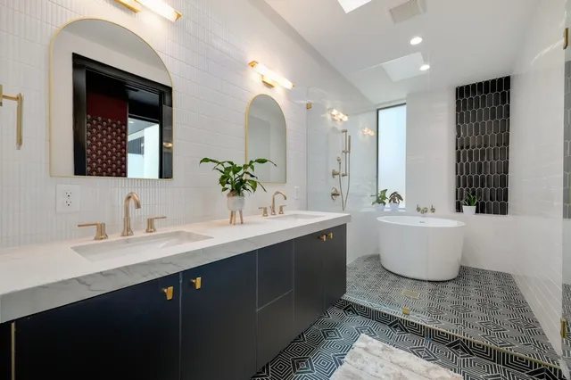a bathroom with a sink a potted plant and a bathtub