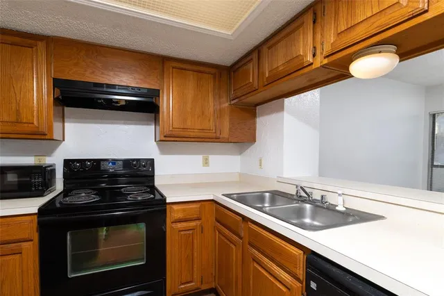 a kitchen with stainless steel appliances a stove a sink and cabinets