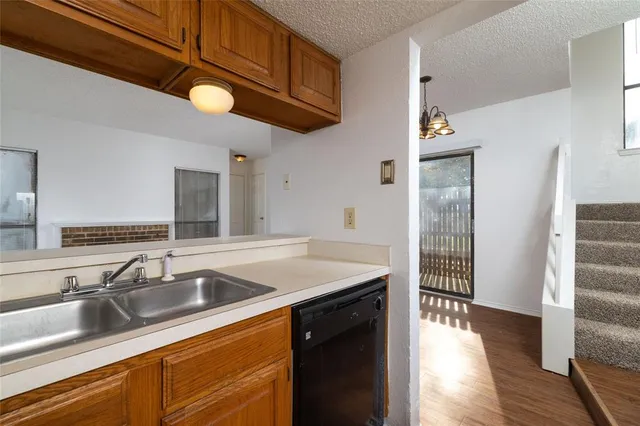 a kitchen with stainless steel appliances granite countertop a sink and dishwasher with wooden floor