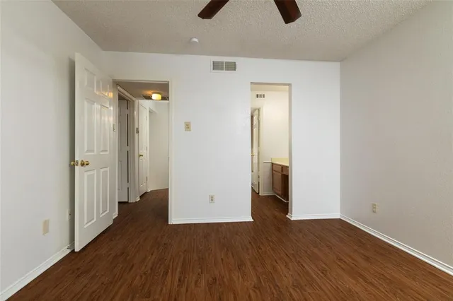 an empty room with wooden floor and entrance