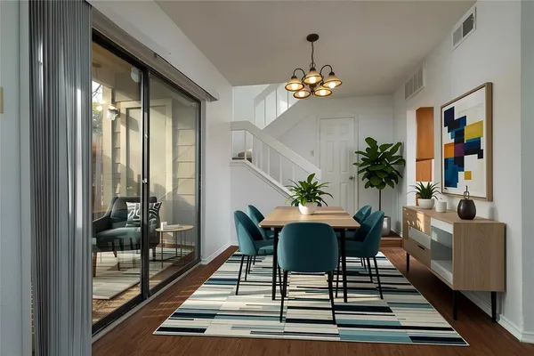 a view of a dining room with furniture a chandelier and wooden floor